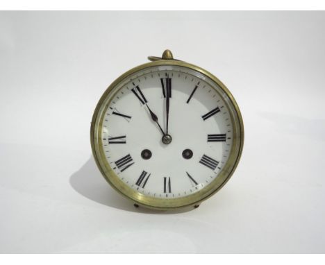 A brass drum form desk clock, white enamel Roman numeral dial with twin barrel movement striking a bell, back plate stamped R
