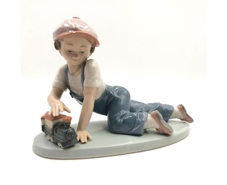 Boy playing with a train on the board - Lladro number 01007619. TODOS A BORDO Artist: Antonio Ramos Issued: 1992 Dimensions: 