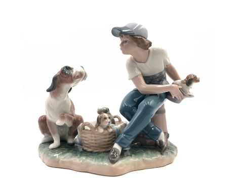 Boy playing with dogs - Lladro number 01005376. ESCONDIENDO UN CACHORRO (with box). Artist: Regino Torrijos Issued: 1986 Dime