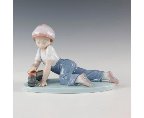 Boy playing with a train on the board - Lladro number 01007619. TODOS A BORDO (with box). Artist: Antonio Ramos Issued: 1993 