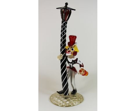 A large Murano glass sculpture of a clown leaning on a lamp post, H. 51cm.