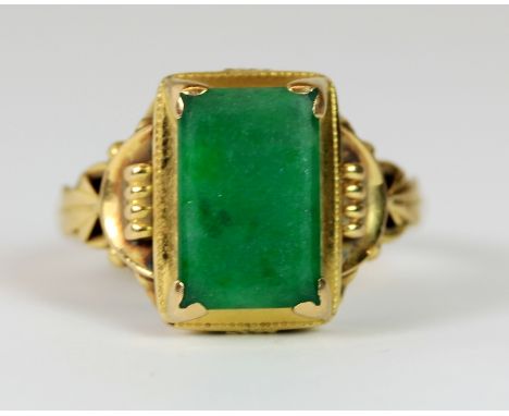 A 22ct gold ring set with an oblong jade (Q).