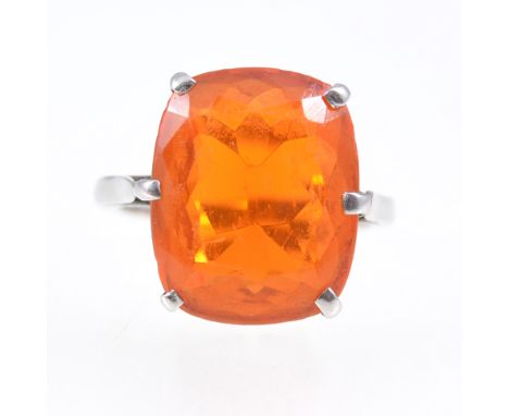 A Mexican fire opal dress ring, the rectangular cushion cut stone six claw set in an all white metal mount, plain 1.8mm wide 