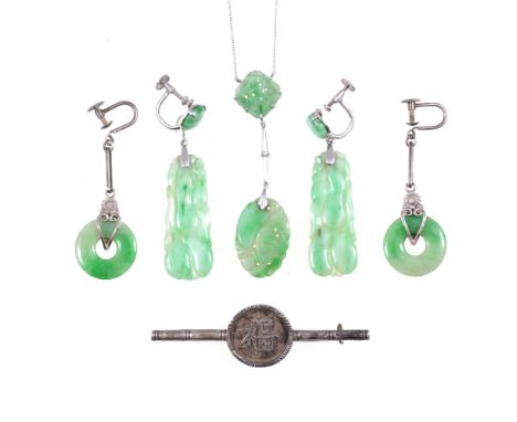 A carved jade pendant, with white metal fittings on a fine trace link chain and pair of flat baton drop earrings, both stampe