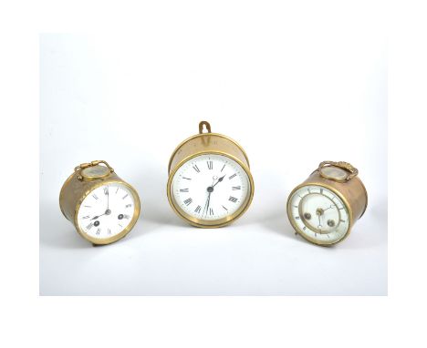 Three brass cased ships clocks, all having white enamel dials with roman numeral chapter rings in circular brass barrel cases