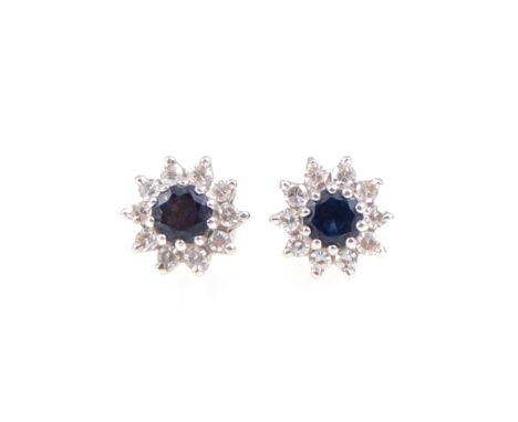 A pair of sapphire and diamond circular cluster earstuds, the 4mm sapphires claw set and surrounded by ten, eight cut diamond