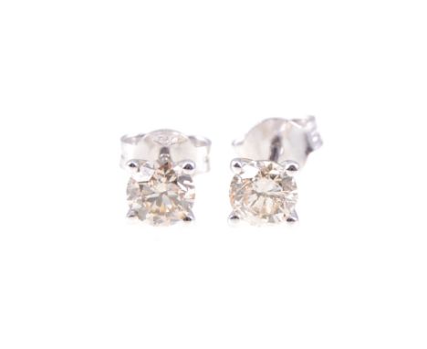 A pair of diamond single stone earrings, one brilliant cut diamond four claw set to each, in all white metal mounts stamped 7