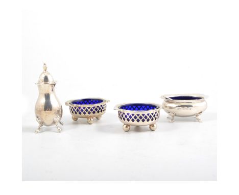 A silver three piece condiment set plain cut edge design on four paw feet, with spoons, hallmarked Birmingham 1977, a silver 