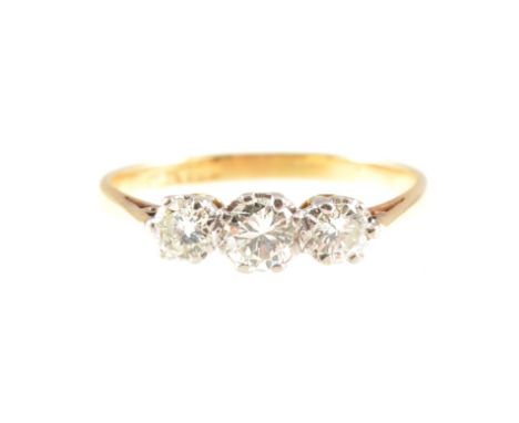 A diamond three stone ring, the brilliant cut stones, slightly graduating in size, claw set in a yellow and white metal tradi