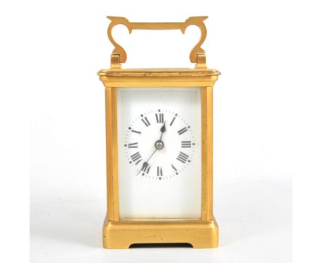 A French gilded brass carriage clock striking on a gong, white enamel dial with roman numeral chapter ring, oval bevelled gla