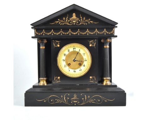 A black slate mantel clock with architectural pediment inlaid with gilt decoration, free standing column to each side, cream 