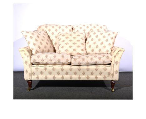 Modern high back two-seat sofa, floral medallions on cream ground, stained beech supports, W149cm x D90cm.