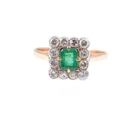 A square emerald and diamond cluster ring, the rectangular  cut emerald claw set and surrounded by twelve brilliant cut diamo