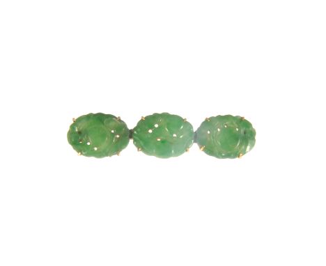 A jade set bar brooch, three oval carved and pierced discs each 15mm x 10mm, claw set on a yellow metal frame 47mm long.