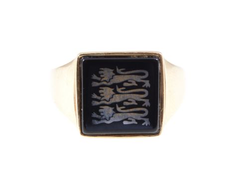 A gentlemans signet ring, the 12mm square black onyx head inlaid with three lion passant, plain shank and shoulders stamped 9