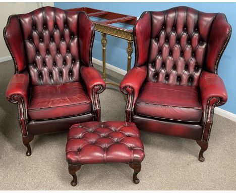 Pair of red leather button back armchairs (both with a repair to the arm) &amp; a footstool
