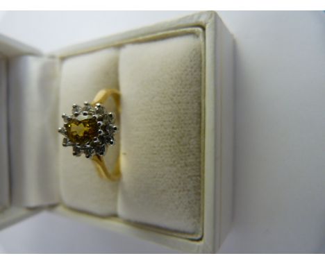 18ct Yellow Gold, yellow sapphire and Diamond cluster ring. The Yellow oval centre stone in approx 5.8mm x 4.5mm and is surro