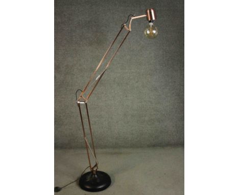 A contemporary floor standing Anglepoise lamp, with a copper frame on a circular ebonised base. H.180 Dia.33cm. 