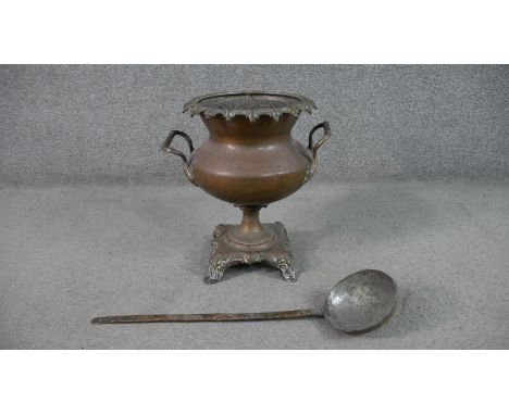 A copper twin handled urn on foliate form base along with a 19th century hammered copper jam ladle. H.36 W.36cm (largest) 