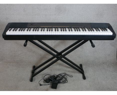 An electric Casio keyboard and stand. H.80 W.135cm 