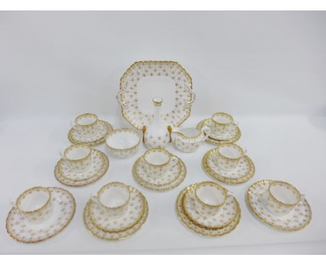 Spode white glazed bone china nine place teaset with gilt edged rims and Fleur de Lys pattern, comprising cups, saucers, side