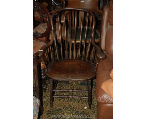 An old American style solid seated Elbow Chair having stick back and sides, supported on turned front legs with well worn tur