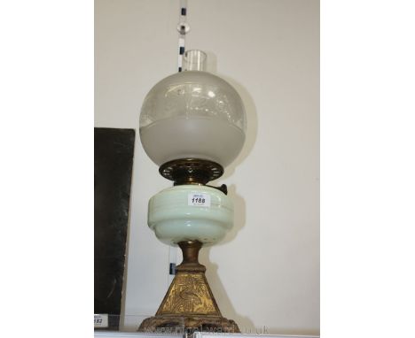 An Oil Lamp with pale green glass reservoir and etched glass shade