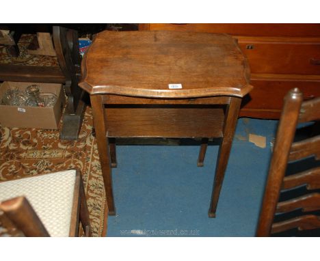 A shaped top Oak Occasional Table having under shelf and standing on square legs.  22" x 16" x 28 1/2" high.