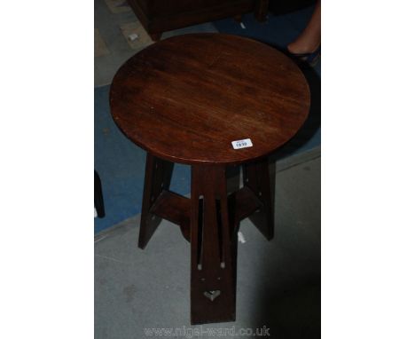 An Oak Arts and Crafts circular Occasional Table, the circular top 17" diameter, supported by three fretworked legs with doub