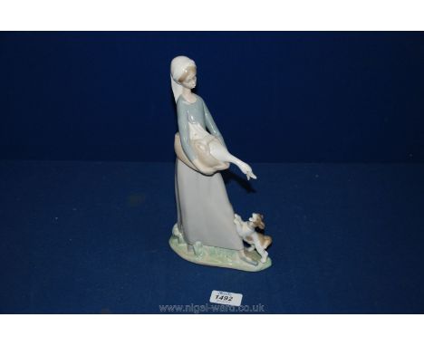 A Lladro figure of a girl with a goose having a puppy at her feet