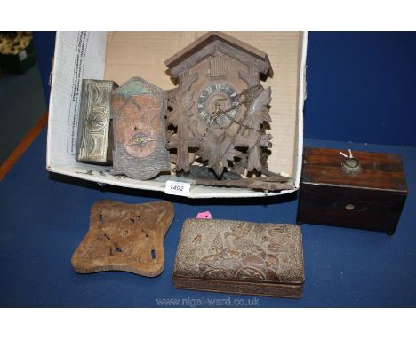 An old wooden cuckoo clock, a bird embossed wooden box, two wooden teapot stands, a small tea caddy, etc