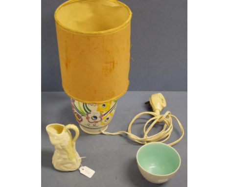 Three various ceramic table items including Belleek cream jug; a Poole table lamp, with shade; and a Poole sugar bowl. Height