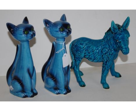 Pair blue ceramic cat figures each a seated cat, unmarked, (height 21cm approx, each); together with a blue ceramic donkey fi