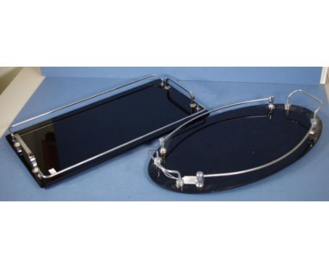 Two matching art deco black glass trays 1 oblong, the other oval, each with raised silver plate gallery. Length 45cm approx (