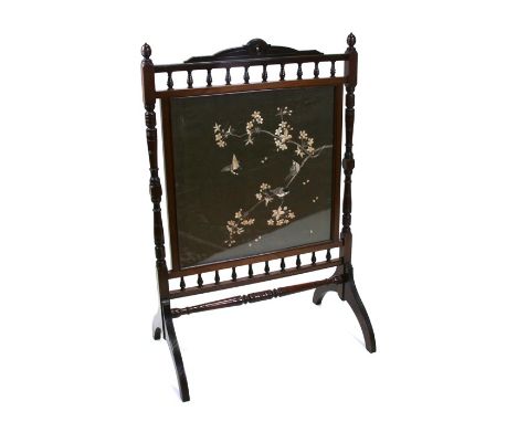 An Edwardian mahogany fire screen with rectangular silk work panel decorated with birds and foliage, 96cms (26ins) wide.