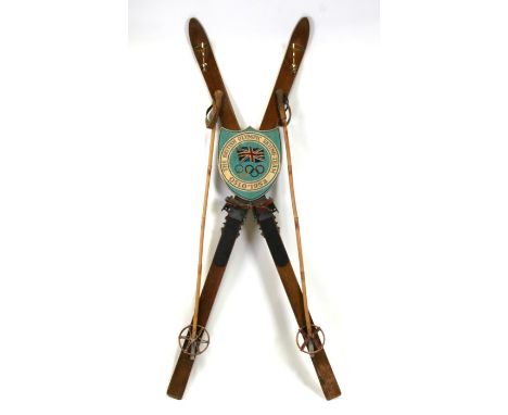 A pair of vintage skis with later painted Olympic plaque, constructed as a coat stand, 170cms (67ins) high.