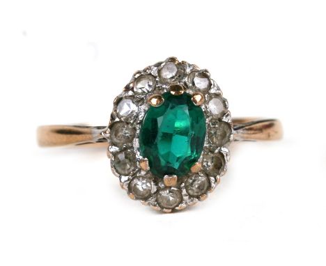 A 9ct gold cluster dress ring set with a central oval green stone, approx UK size 'O'.Condition ReportOne diamond missing.