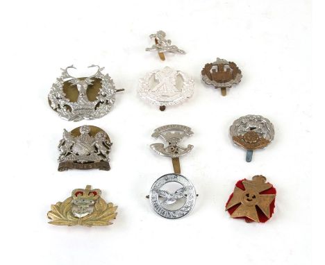 An assortment of ten British Military cap badges including: Kings Royal Rifle Corps, Cameron Highlanders, Hampshire Regiment,
