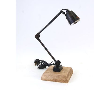 A black metal industrial or machine E.D.L. anglepoise lamp mounted on a contemporary wooden base