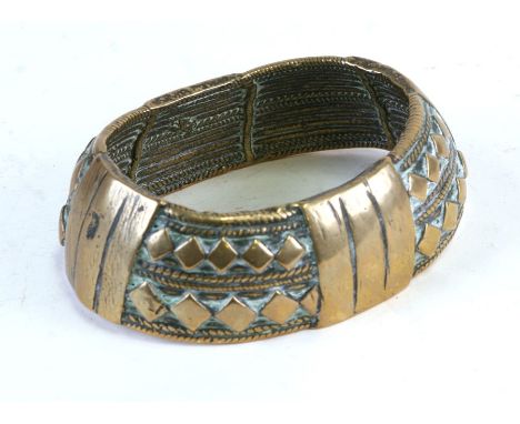 An African brass bangle, 11cms (4.25ins) wide.
