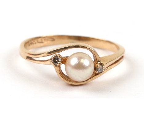 A 14ct gold ring set with a central pearl flanked by two diamonds, approx UK size 'I'.