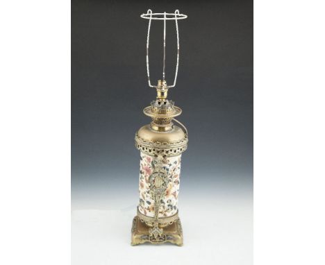 A 19TH CENTURY GLAZED CERAMIC CYLINDRICAL COLUMN OIL TABLE LAMP, containedn in a Chinese cast brass frame and raised on shape