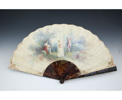 A FRENCH HAND PAINTED FAN, with tortoise shell guardsticks, the vellum leaf depicting a garden scene with a dancing couple an