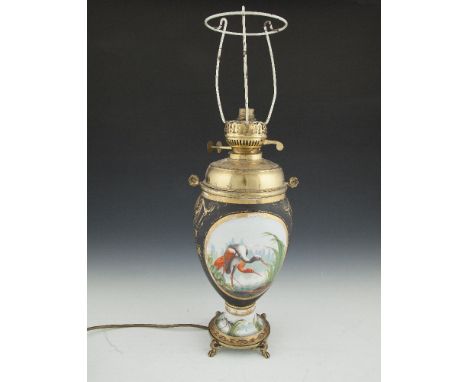 A 19TH CENTURY PAINTED PORCELAIN CIRCULAR BALUSTER OIL TABLE LAMP, decorated with oval panels of storks in wetlands and raise