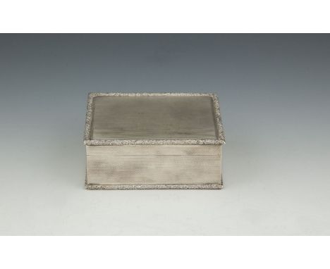 A SILVER TABLE BOX AND COVER, London 1965, of rectangular form, with engine turned decoration and raised foliate cast border,