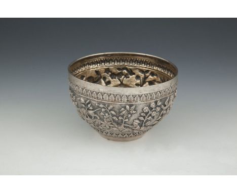 AN INDIAN REPOUSÉE WHITE METAL CENTRE BOWL, 19th century, decorated with a continuous hunting scene between leafy cast border
