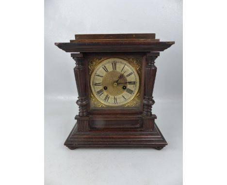 Architectural style mantle clock with brass face and Roman numeral chapter ring