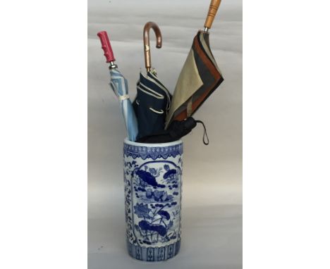 A ceramic umbrella stand of white ground with blue transfers of floral design 46cm together with 4 umbrella