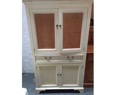 A Laura Ashley Cupboard with carved cornice, two doors with French cane panels, drop handles and one internal shelf over, one