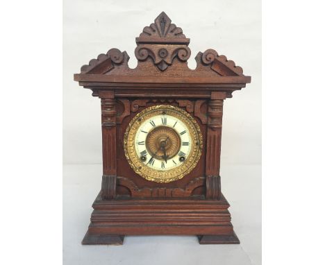 A wooden carved cased mantel clock, movement by Ansonia Clock Co, New York, USA patented June 18.1882, cream and gilt dial wi